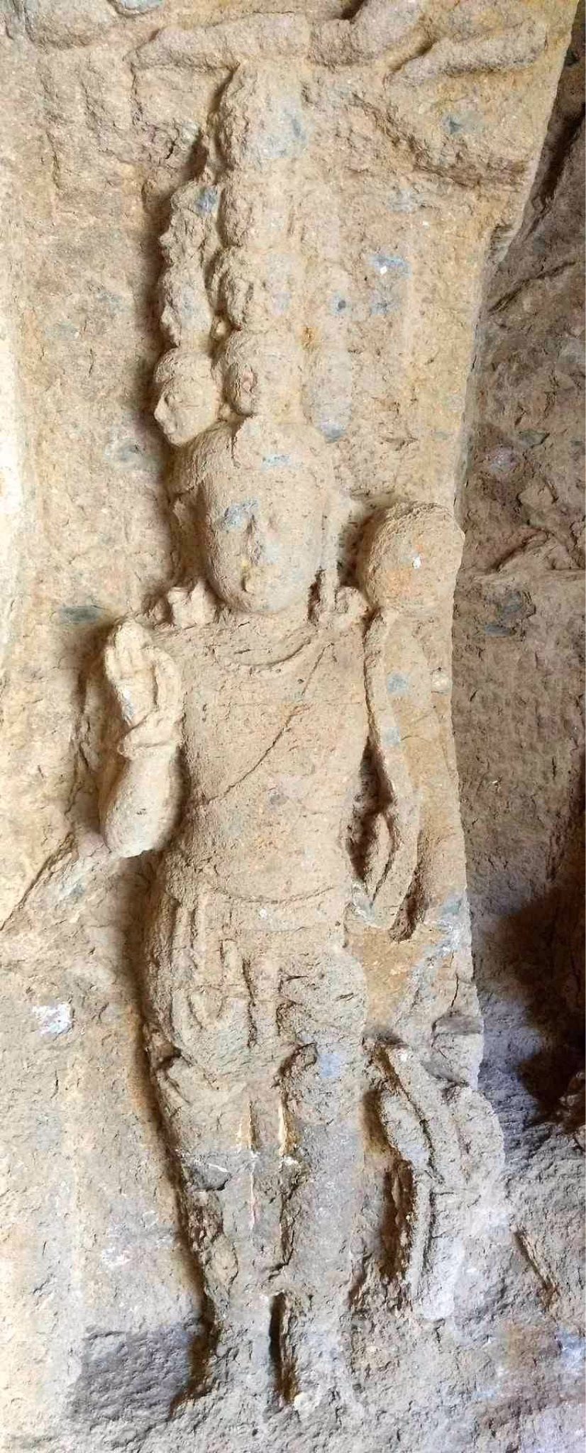 Stone relief carving of the Eleven-Headed Avalokiteshvara standing inside Cave 41 at Kanheri, showing the deity with stacked heads and multiple arms.